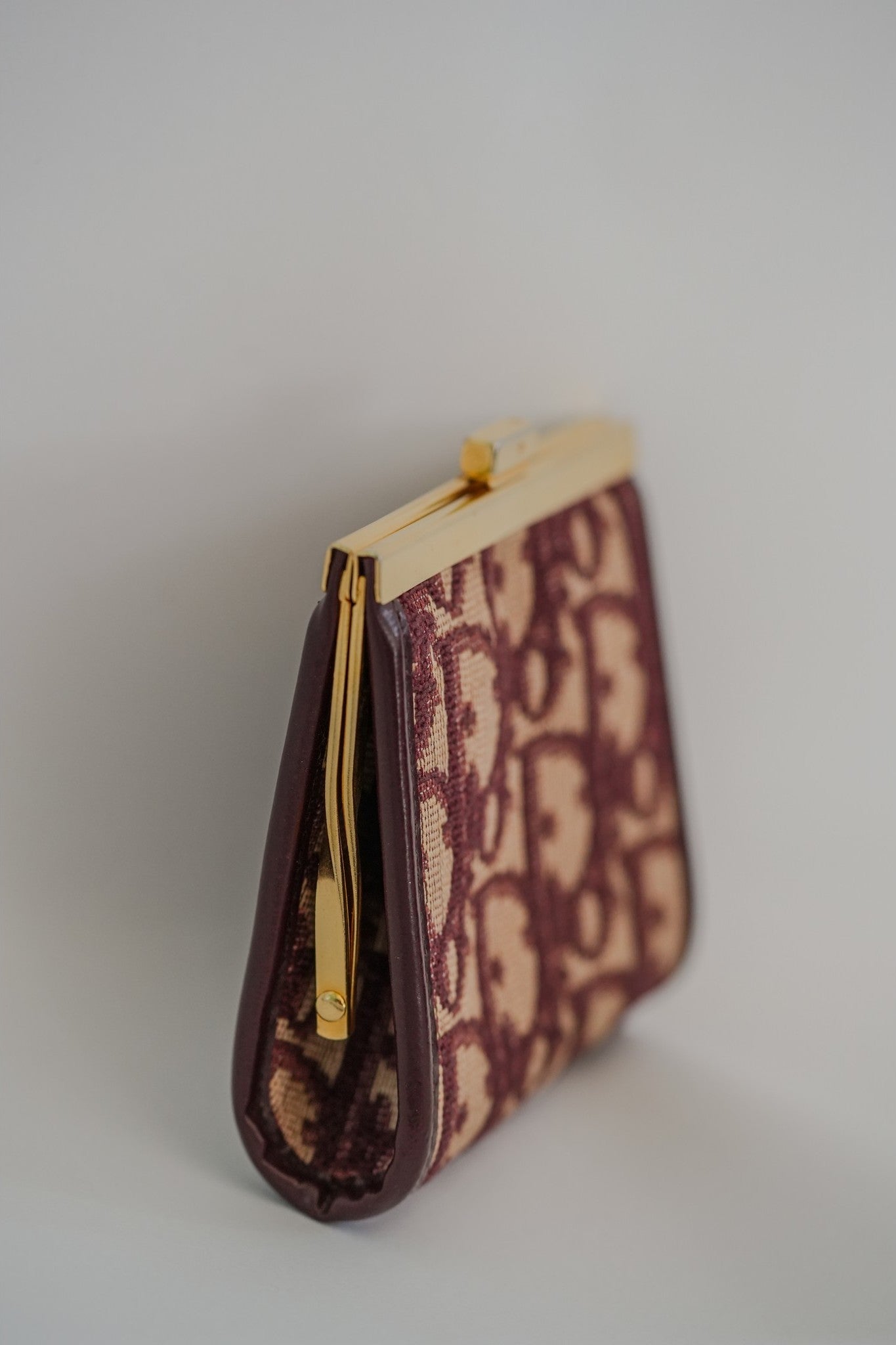 Vintage Christian Dior Trotter Oblique kisslock coin purse side view, burgundy leather and canvas