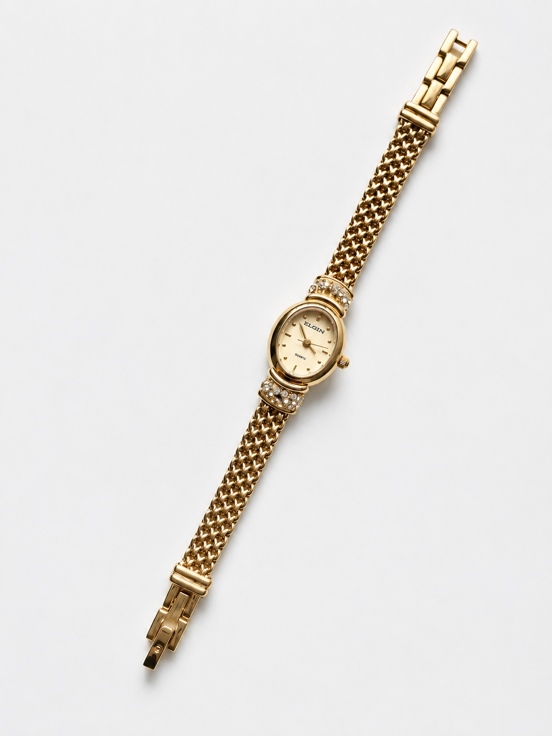 Gold watch with a chain-like bracelet on a white background