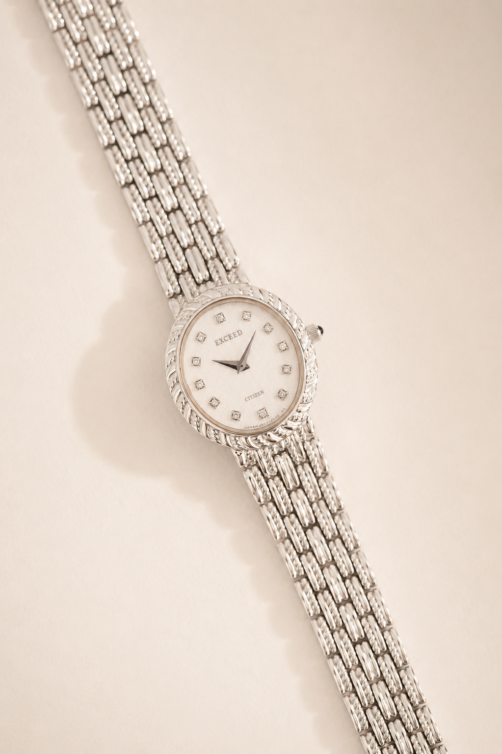 Silver watch with a detailed face on a beige background