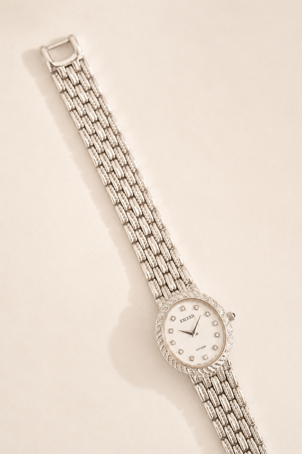 Silver watch with a chain strap on a beige background