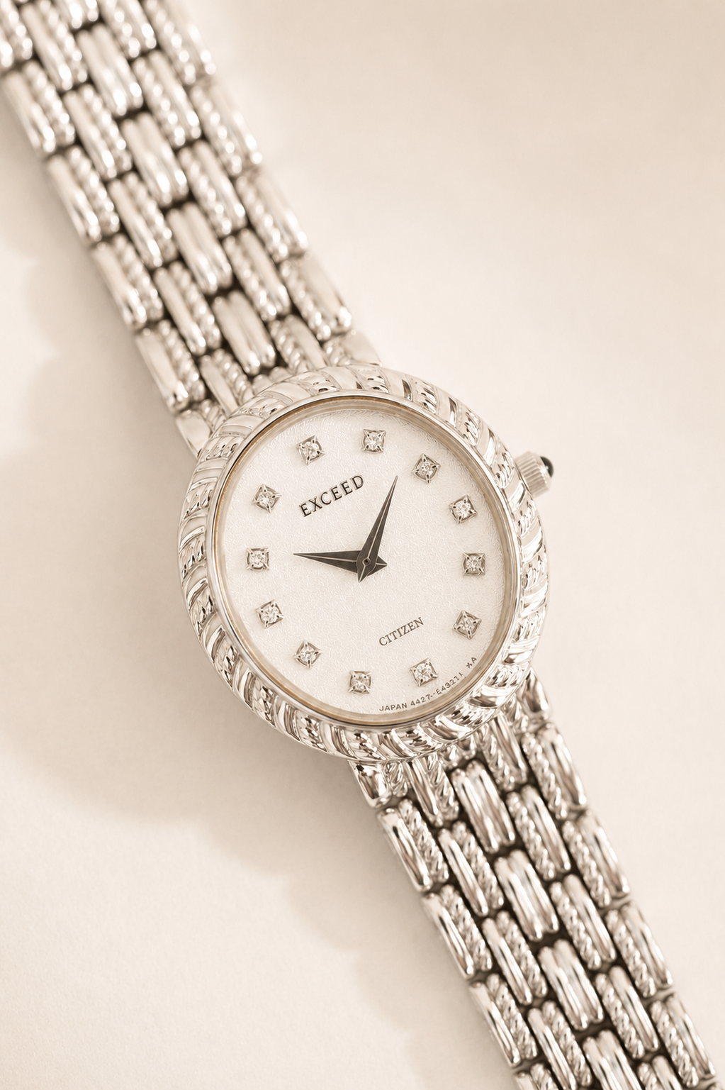 Silver wristwatch with decorative band on a light background