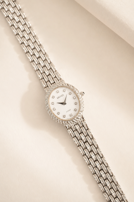 Silver watch with a chain strap on a beige background