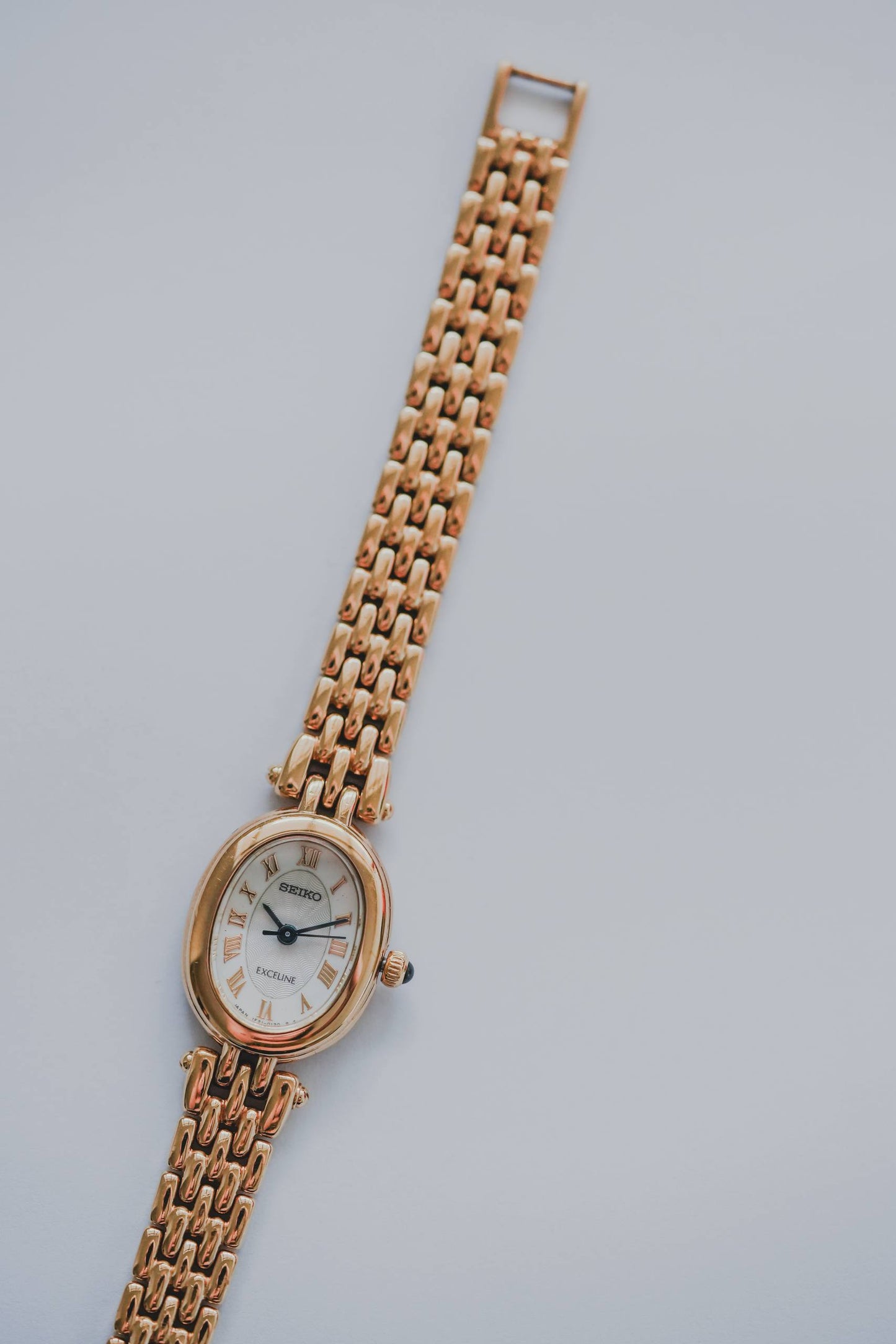 Seiko Exceline oval case yellow gold tone white guilloché dial Roman numerals ladies watch